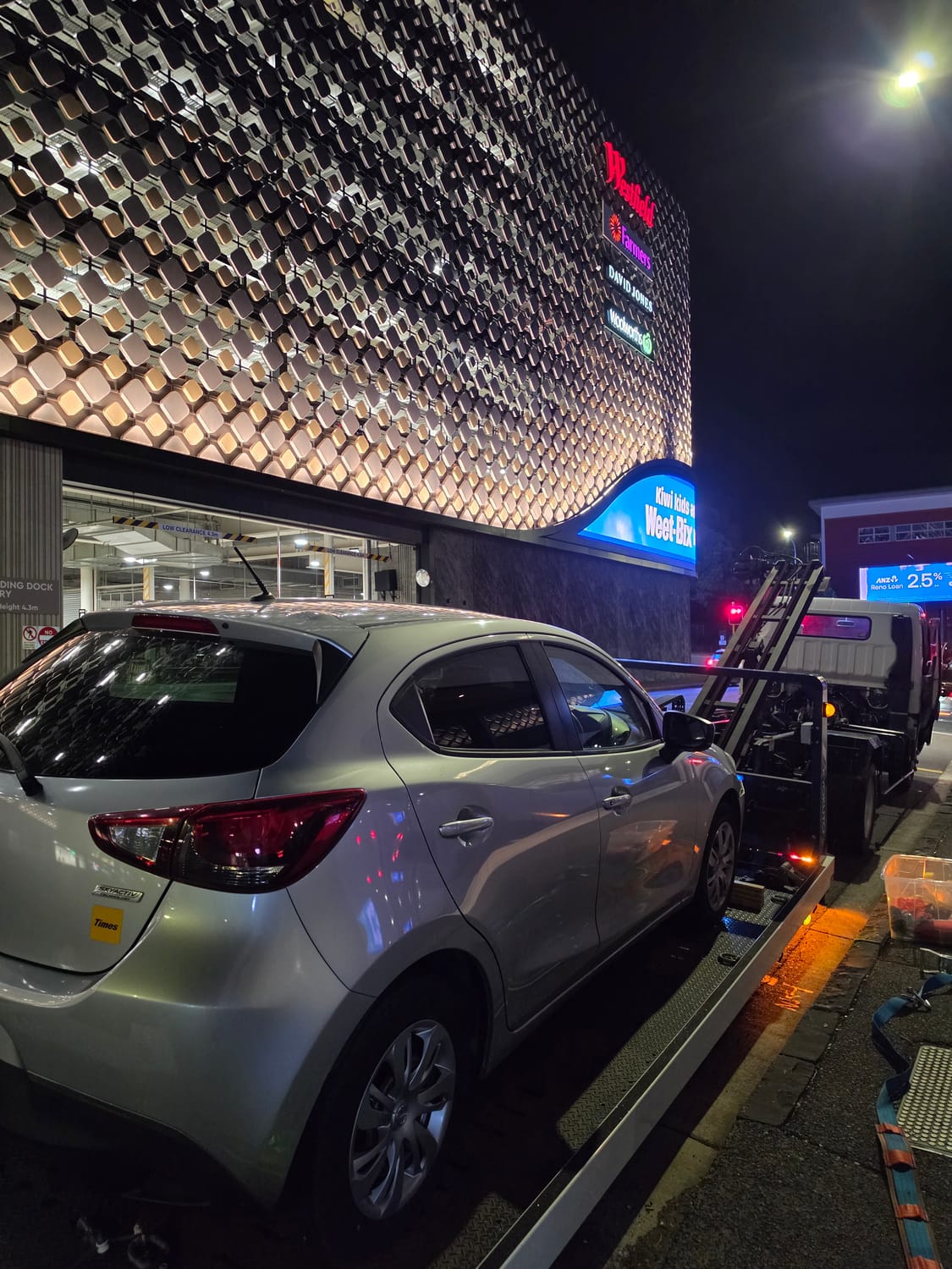 Silver hatchback being lowered onto the kerb from a Drive1 Towing flatbed.